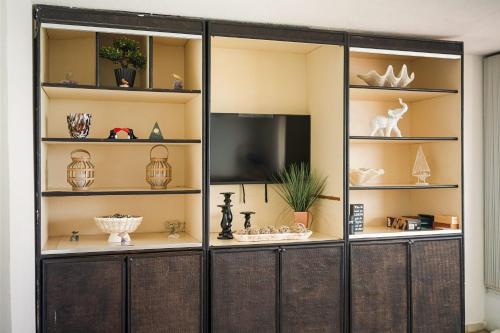 a display cabinet with a television in a room at Oceanfront Paradise - Spacious and Family Friendly in San Juan