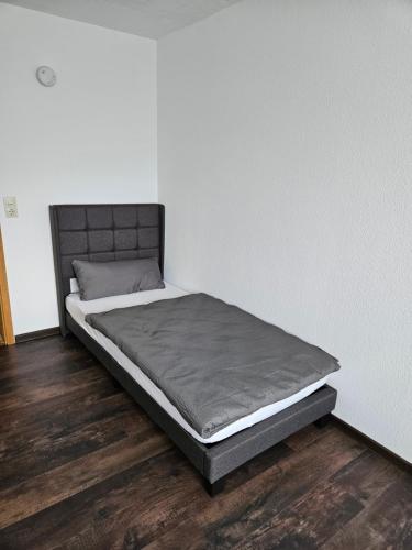 Cama en habitación con suelo de madera en Große Ferienwohnung in ruhiger Lage mit toller Aussicht in Triberg, en Triberg