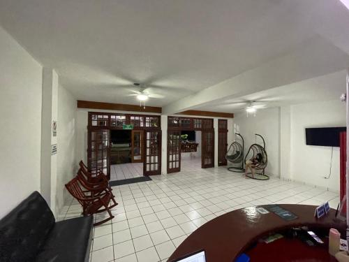 - un salon avec une table, des chaises et une télévision dans l'établissement Hotel Ocean View, à San Juan del Sur