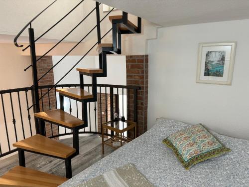 a living room with a spiral staircase and a bed at Apartment Tena in Senj