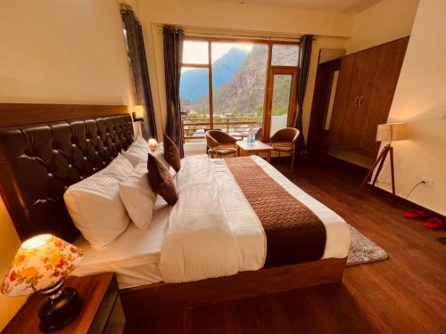 a bedroom with a bed with a view of a mountain at Hotel New Panchali With Mountain view By Winterline, Kasol in Kasol