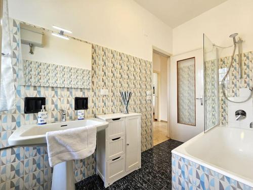 uma casa de banho com um lavatório, uma banheira e um chuveiro em Parking,WiFi, Netflix - Sunny Sea View Haven em Rapallo