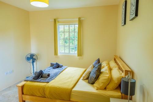 a bedroom with a bed with yellow sheets and a window at Pierocks Highgate Entire house Free Parking and WI-FI in Arnos Vale