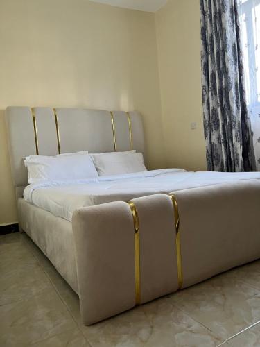 un grande letto in una stanza con finestra di Art’s Suites a Kisumu