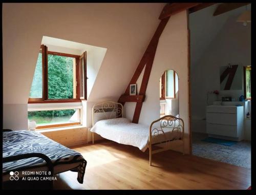 a bedroom with two beds in a attic at Chez Baptistète in Labastide