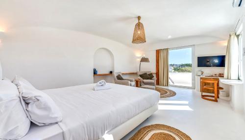 a white bedroom with a large bed and a living room at Villa Ravino Secret Retreat in Ischia
