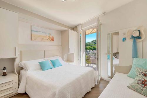 a white bedroom with a bed and a balcony at Dreams Guest House in La Spezia
