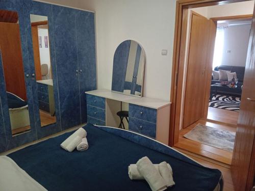 een slaapkamer met een blauw bed en een spiegel bij Šumska Vila in Bajina Bašta