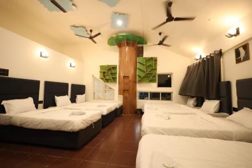 une chambre avec 4 lits et des oiseaux au plafond dans l'établissement Hotel Parashar Palm, à Nagpur