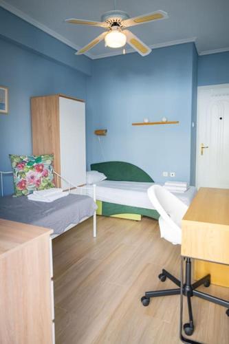 a room with two beds and a ceiling fan at Spacious and comfy apartment in Nea Moudania