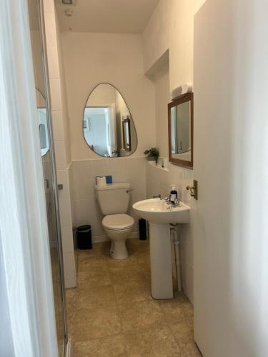 uma casa de banho com um WC, um lavatório e um espelho. em The Yacht Inn em Penzance