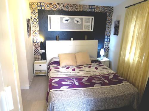 1 dormitorio con 1 cama en una habitación con paredes azules en Lightbooking Vejer de la Frontera, en Vejer de la Frontera