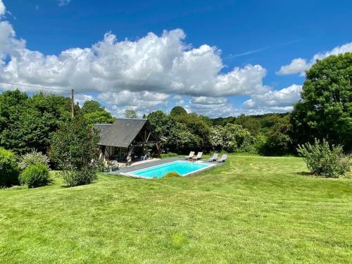 une grande cour avec une piscine et une maison dans l'établissement Le Petit Pressoir, à Neuville-sur-Touques
