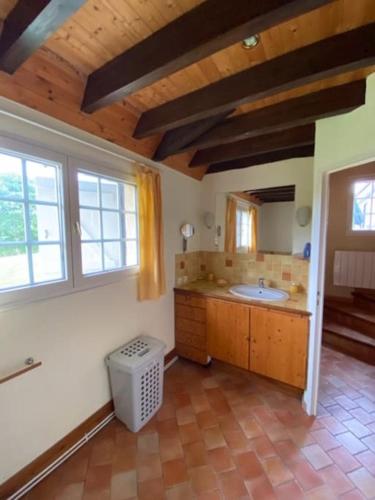 La grande salle de bains est pourvue d'un lavabo et d'une fenêtre. dans l'établissement Le Petit Pressoir, à Neuville-sur-Touques