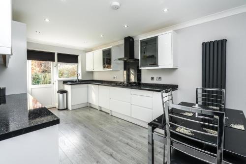 Copthorne的住宿－Lovely Modern Room，厨房配有白色橱柜和黑色台面