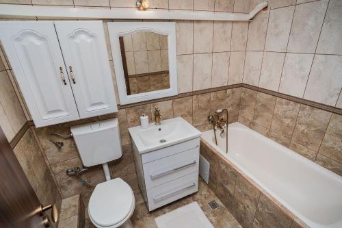 La salle de bains est pourvue de toilettes, d'un lavabo et d'une baignoire. dans l'établissement Diana Resort, à Timişoara