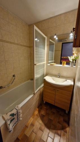 une salle de bain avec un lavabo, une baignoire et un miroir dans l'établissement Capitelles Appart accès direct plage et piscine - Balcon Parking - ref Tedal, à Saint-Cyprien
