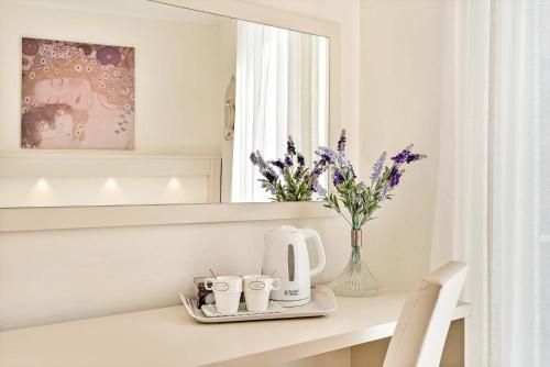 una mesa con cafetera y un jarrón de flores en Dreams Guest House, en La Spezia