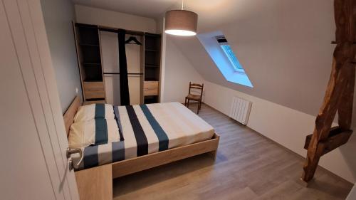 - une chambre avec un lit et un escalier avec une fenêtre dans l'établissement Grande Maison au calme à 5mn de la plage, à Moëlan-sur-Mer