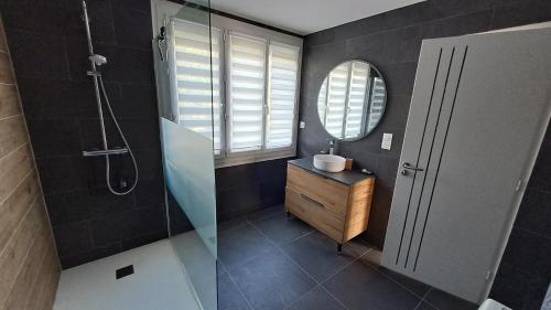 une salle de bain avec une douche, un lavabo et un miroir dans l'établissement Grande Maison au calme à 5mn de la plage, à Moëlan-sur-Mer