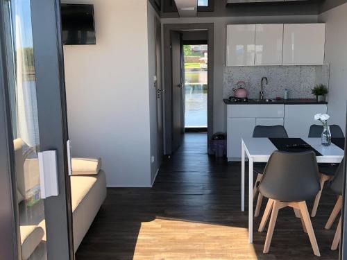 Il comprend une cuisine et un salon avec une table et des chaises. dans l'établissement Houseboat in Kamien Pomorski, à Kamień Pomorski