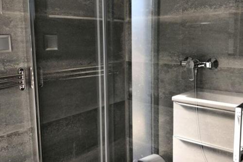 una ducha con una puerta de cristal junto a un lavabo en Houseboat in Kamien Pomorski en Kamień Pomorski