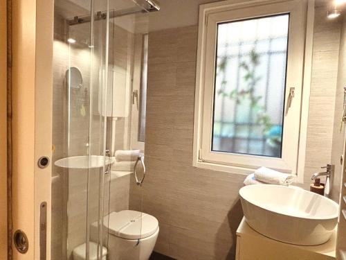 a bathroom with a sink and a toilet and a window at Dorsoduro House in Venice