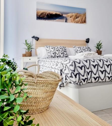 a bedroom with a bed and a table with a basket at Adosadito Playa Oliva in Oliva