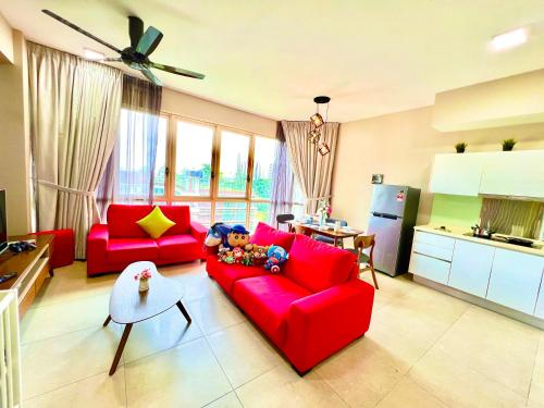 uma sala de estar com um sofá vermelho e uma cozinha em Legoland-3min Walk-HappyDream Suite at Afiniti -8pax-Cozy,Comfy&Convenience 2BR with Bathub em Nusajaya