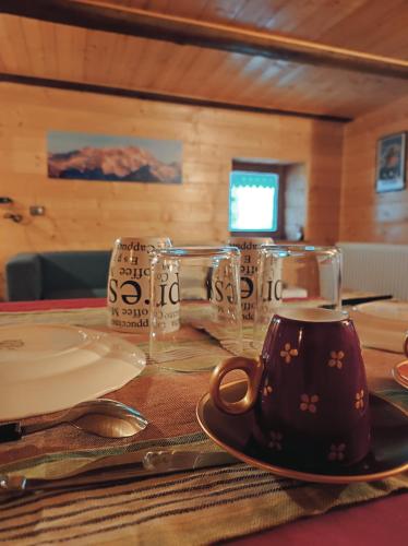 a table with a coffee cup and glasses on it at La Casa del Busso in Boccioleto