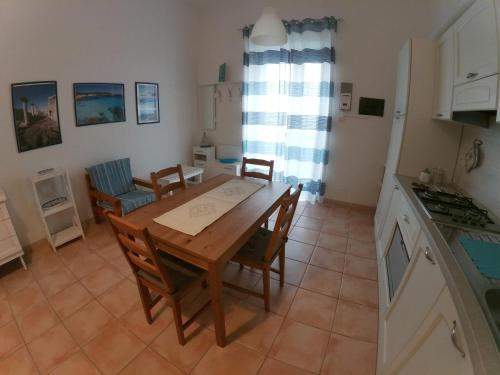 cocina y comedor con mesa de madera y sillas en Casa Eleonora, en Porto Torres