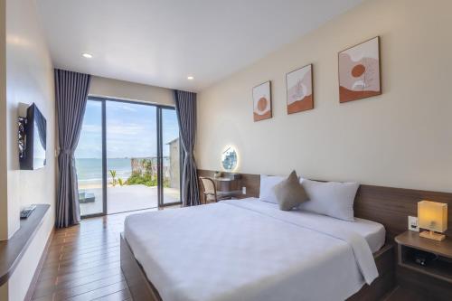 um quarto com uma cama grande e vista para o oceano em Wave Sound Beach House Phu Quoc em Phu Quoc