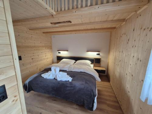 una camera da letto con un grande letto in una camera in legno di Fernblick Chalet Gruber a Grafendorf bei Hartberg