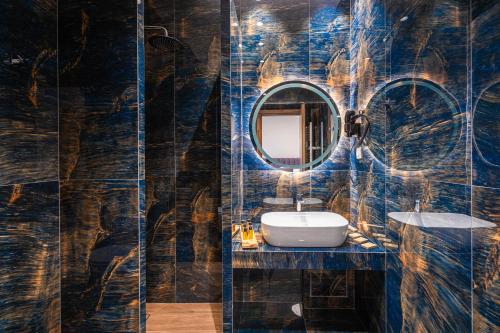 a bathroom with a sink and a mirror at FLOARA DI MUNTE Forest Luxury Suites in Metsovo