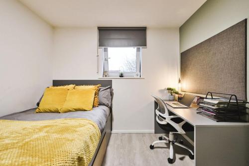 - une chambre avec un bureau et un lit avec une couverture jaune dans l'établissement For Students Only Private Rooms with Shared Bathroom at Queens Court in Leicester, à Leicester