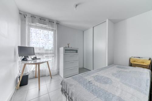une chambre avec un lit et un bureau avec un ordinateur dans l'établissement GuestReady - Apt. Lumineux à Villeurbanne, à Villeurbanne