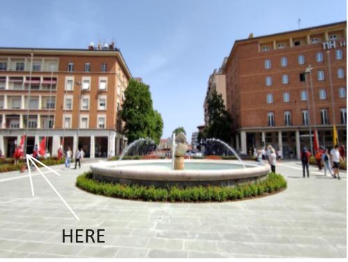a fountain in a square in a city with buildings at CAPOSTAZIONE22 in Pisa