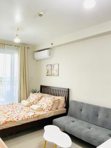 a bedroom with a bed and a couch at Condo near Airport in Lapu Lapu City