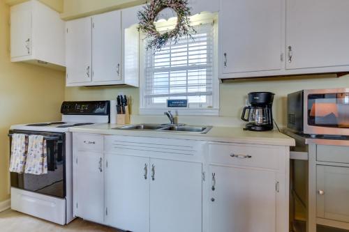 a kitchen with white cabinets and a sink at Steps to Ocean North Myrtle Beach Condo with Porch! in Myrtle Beach