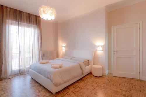 a bedroom with a large white bed and a chandelier at Casa per vacanze Mevania in Bevagna