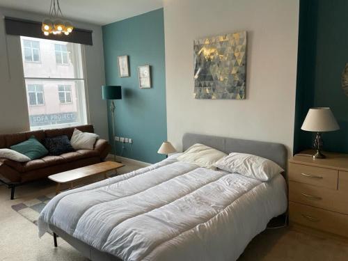 a bedroom with a large bed and a couch at Wonderful 3 Bed in Old Market in Bristol