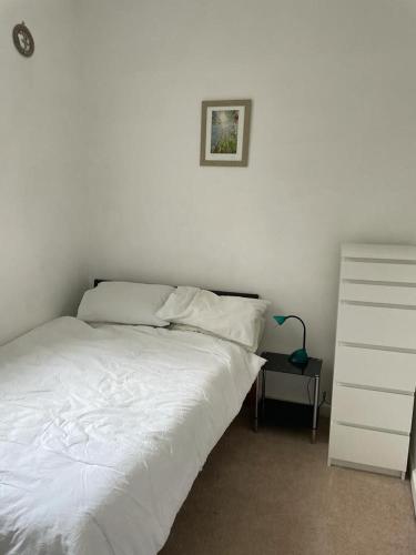 a bedroom with a white bed and a dresser at Wonderful 3 Bed in Old Market in Bristol