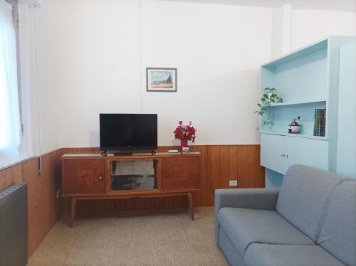 sala de estar con TV y sofá en Affitta camere Via Piave, en Foligno