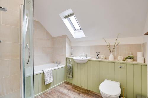 een badkamer met een toilet, een wastafel en een douche bij NEW Toad Hall Lake Access & Pet Friendly in Somerford Keynes