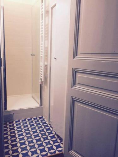 La salle de bains est pourvue d'une porte et de carrelage. dans l'établissement Appartement de charme de 60 m2 entre Montmartre et Batignolles, à Paris