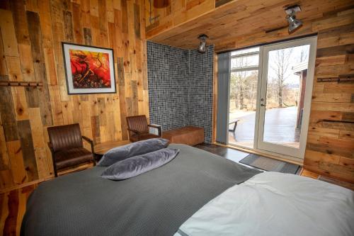 um quarto com uma cama num quarto com paredes de madeira em Gljásteinn by Golden Circle em Laugarvatn