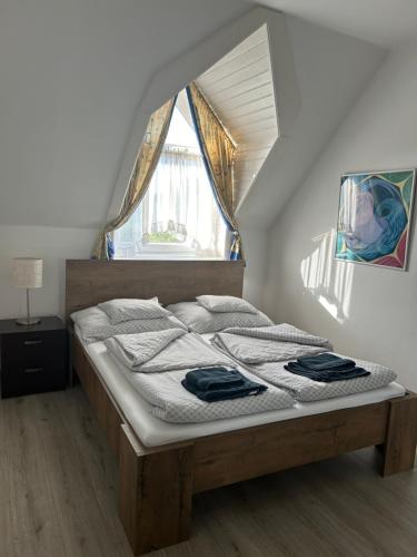 a bed sitting in a room with a window at Sára magánszálláshely Debrecen in Debrecen
