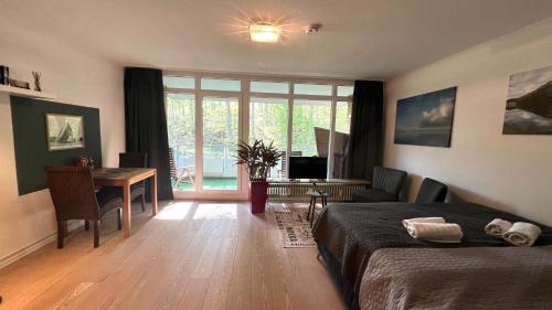 a bedroom with a bed and a table and a desk at Ruheoase am Strand Wassersleben in Harrislee