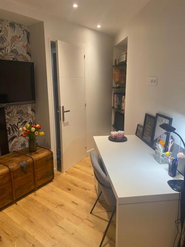 Cette chambre comprend un bureau, une télévision et une table. dans l'établissement CHAMBRE CHEZ L'HABITANT CENTRE VILLE DE LYON, à Lyon