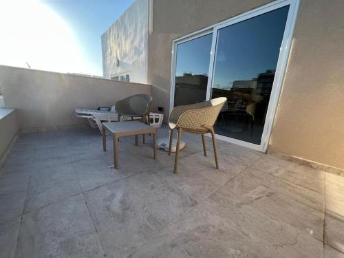 a patio with two chairs and a table on a balcony at Sweet 1-bedroom penthouse in the heart of it all in Il-Gżira